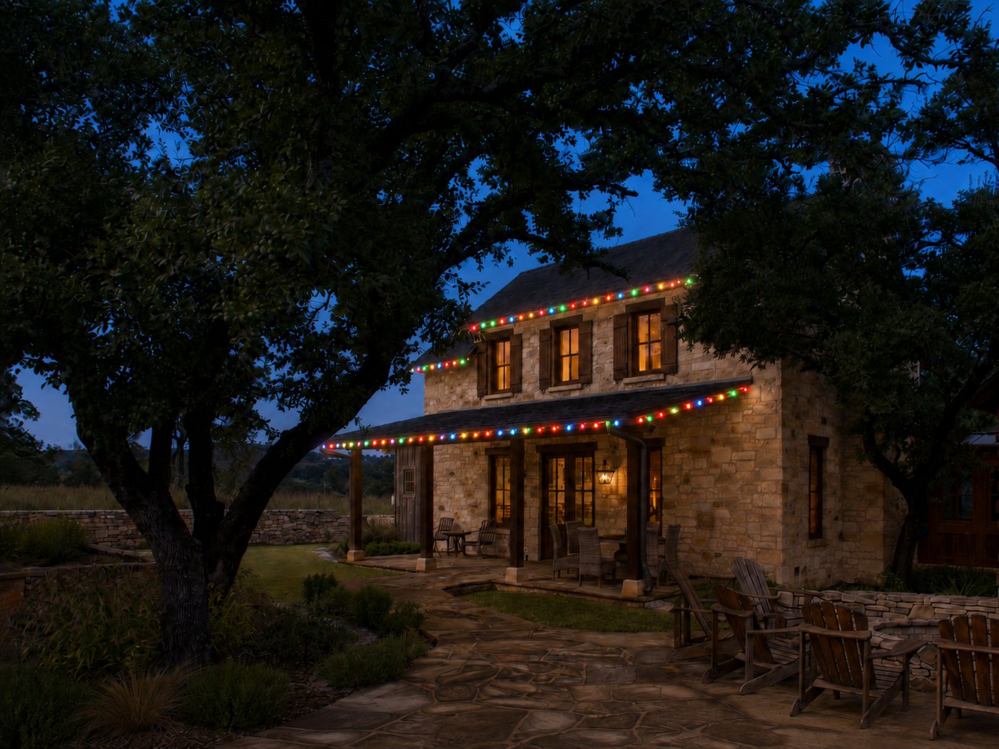 Two-story home with multicolor Christmas roofline lights