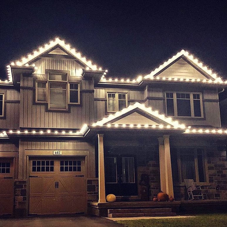 Comfort, Texas home with warm white Christmas lights along multiple roof peaks