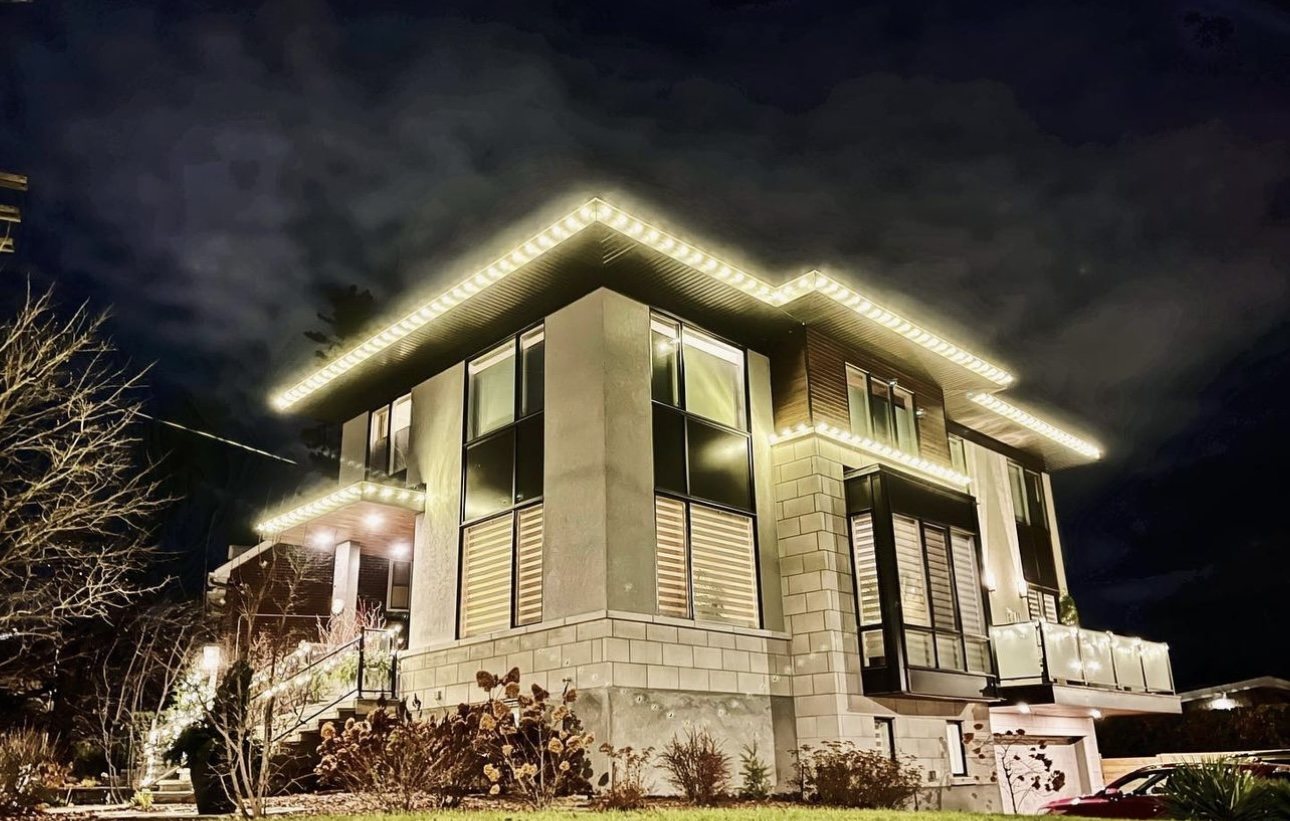 Modern home with warm white C9 Christmas lights following every roofline and overhang at night